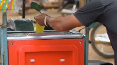 Kamboçyalı adam sokakta müşteri şeker kamışı suyu satıyor. Kamboçya'da, bu süper tatlı suyu çok popüler oldu. Bazen onlar limon ile meyilli tat yapmak için bu suyu karışımı. Kampot, Kamboçya 03 Mart 2018. 