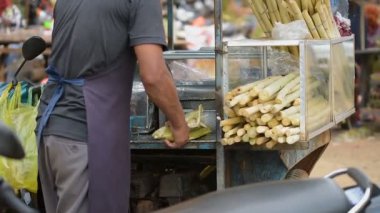 Kamboçyalı adam sokakta makinasıyla şeker kamışı suyu ayıklanan. Kamboçya'da, bu çok tatlı juiceis popülerdir. Bazen onlar limon ile daha iyi tat yapmak için bu suyu karışımı. Kampot, Kamboçya 03 Mart 2018. 