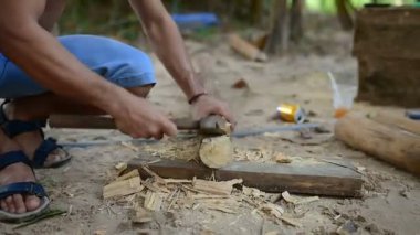 Kamboçyalı adam ahşap ev inşaat yanında balta gibi araçlar kullanılarak geleneksel yol oluşturmak için hazırlar. Diğer ahşap kiriş ile uygun ahşap kiriş deşmek. 28 Kasım 2017, Koh Rong Samloem. Kamboçya. 