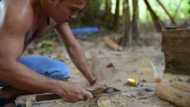 Kamboçyalı adam ahşap ev inşaat yanında balta gibi araçlar kullanılarak geleneksel yol oluşturmak için hazırlar. Diğer ahşap kiriş ile uygun ahşap kiriş deşmek. 28 Kasım 2017, Koh Rong Samloem. Kamboçya. 