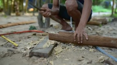 Kamboçyalı adam ahşap ev inşaat yanında balta gibi araçlar kullanılarak geleneksel yol oluşturmak için hazırlar. Diğer ahşap kiriş ile uygun ahşap kiriş deşmek. 28 Kasım 2017, Koh Rong Samloem. Kamboçya. 