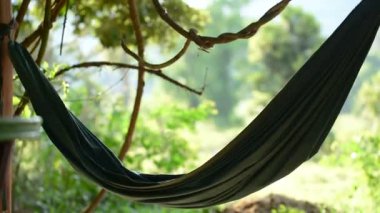 Yeşil hamak rüzgarda gündüzleri ormanın içinde belgili tanımlık geçmiş ile çırpınıyor. Koh Rong Samloem Adası, Kamboçya.