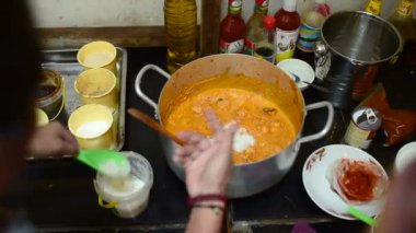 Kamboçyalı adam geleneksel Khmer çorba Khmer Curry, hazırlama dökülen Hindistan cevizi sütü alüminyum pota. 14 Kasım 2018, Koh Rong Samloem Adası. Kamboçya.