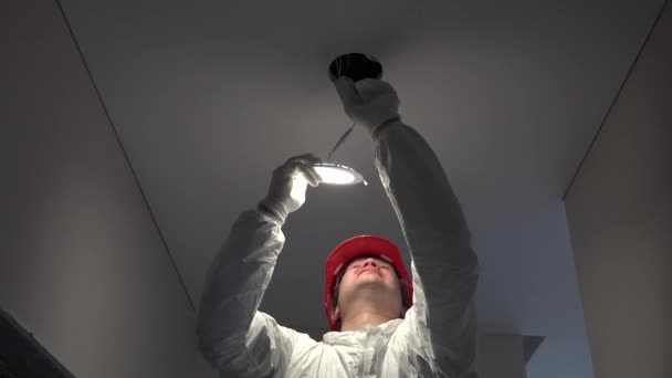 Junger Arbeiter installiert LED-Lampen an Deckenloch — Stockvideo