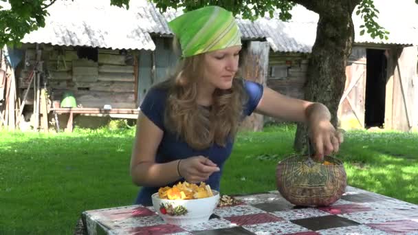 Mujer limpia pequeña cantarela en plato en la mesa en el jardín. 4K — Vídeo de stock