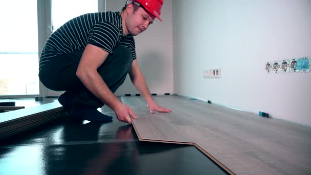 Trabalhador de carpinteiro instalando piso laminado na sala — Vídeo de Stock