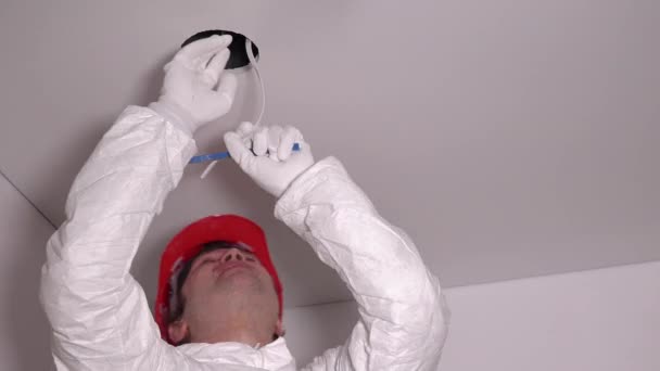Elettricista uomo togliere cavi fili dal foro del soffitto. Installazione luce — Video Stock