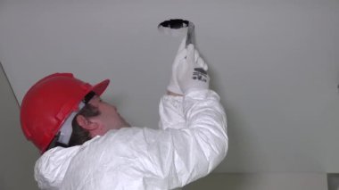 Profesyonel çalışan adam Alçıpan Tavan delik aydınlatma enstalasyonu için yapmak ve merdivenden aşağı in. Atış zoom. 4k Uhd