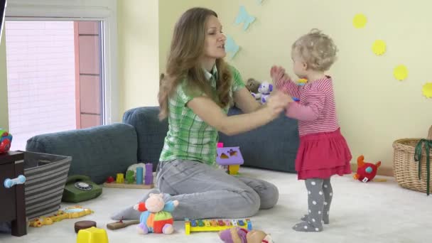 Молодая мама играет в танцы с маленькой дочкой в комнате. 4K — стоковое видео