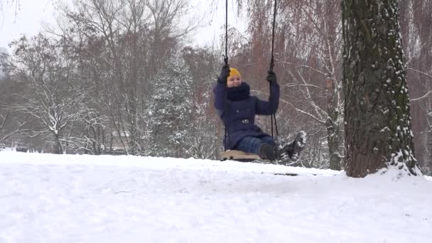 冬の公園で若い女性のスイング。フリータイムは屋外。4 k — ストック動画