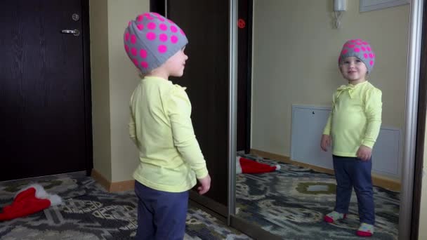 Verspieltes Mädchen mit Hut, das sich im Spiegel küsst. Glückliche Kindheit — Stockvideo