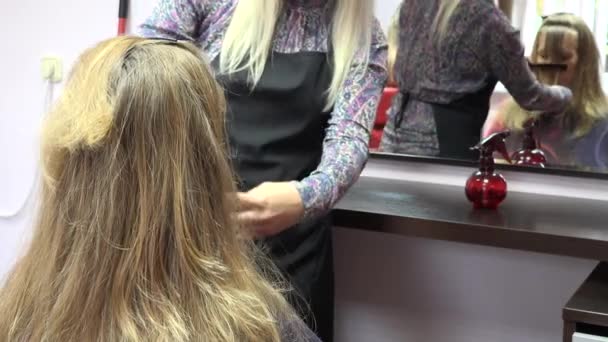 Haarstylist werken op blonde vrouw haar in de salon. Close-up. 4k — Stockvideo