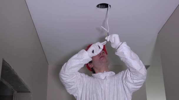 Eletricista homem fazendo instalação de eletricidade no teto em novo edifício — Vídeo de Stock