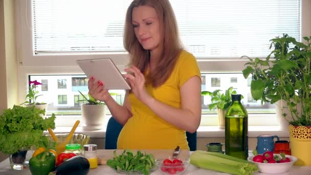 期待的母亲寻找蔬菜沙拉配料使用平板电脑 — 图库视频影像