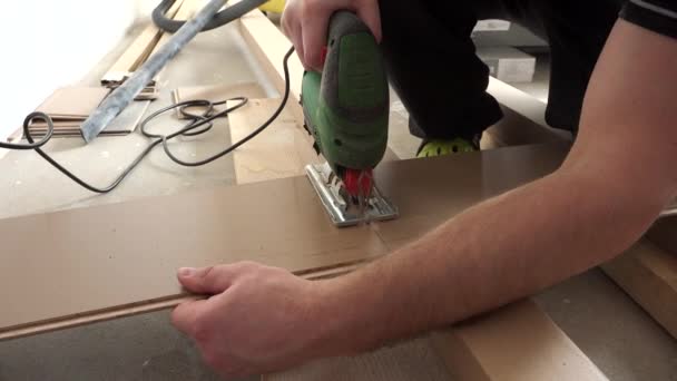 Male worker hands cutting flooring laminate board with jigsaw — Stock Video