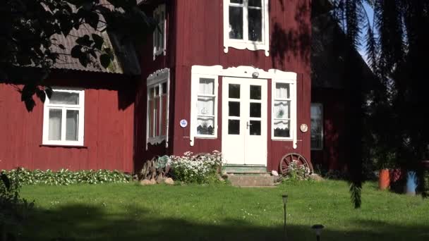 Casa de campo pintada de madera entre ramas de árboles en verano. 4K — Vídeo de stock