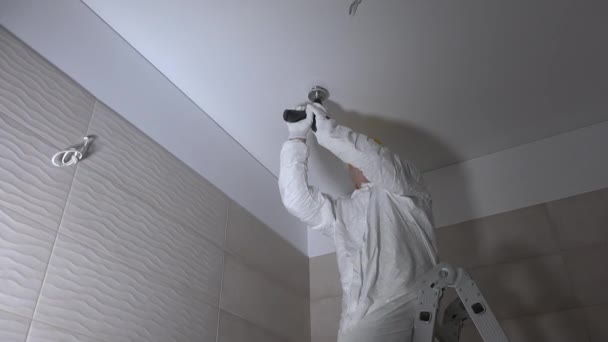 Manual worker drilling hole in ceiling plasterboard for led lighting mounting — Stock Video