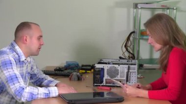 Teknisyen kadın dinle kırık dizüstü bilgisayar ile ilgili istemci adam şikayetler için