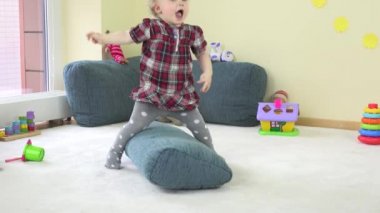 küçük mutlu kız çocuk Oda oyuncak mavi yastık ile oynamak. 4k