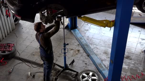 Réparateur réparer le système de freinage sur levé berline voiture dans l'atelier de réparation automobile — Video