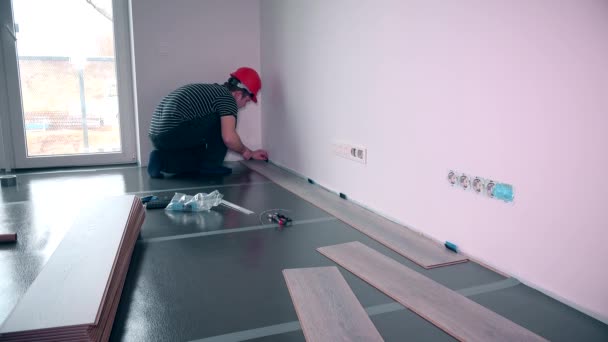 Mann verlegt Laminatboden im Baugewerbe — Stockvideo