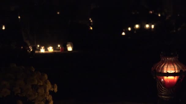 Kerzenlicht, Chrysanthemen blühen nachts auf dem Grabstein. 4k — Stockvideo