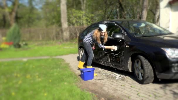 Chica lavar coche negro con esponja jabonosa . — Vídeos de Stock