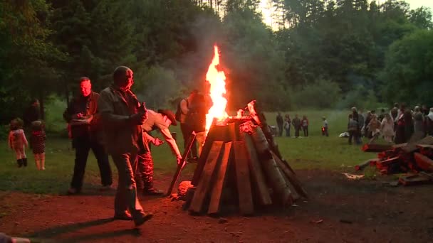 Homens acende fogo com líquido inflamável e papel na lareira ao ar livre — Vídeo de Stock