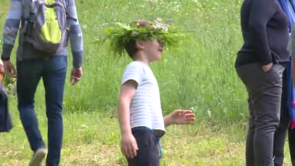 Dítě s kapradinou a korunou květin. Svatojánské prázdniny. — Stock video