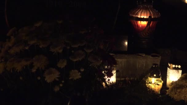 Día de Todos los Muertos. Las velas arden en las tumbas del cementerio por la noche. Cambio de enfoque. 4K — Vídeos de Stock