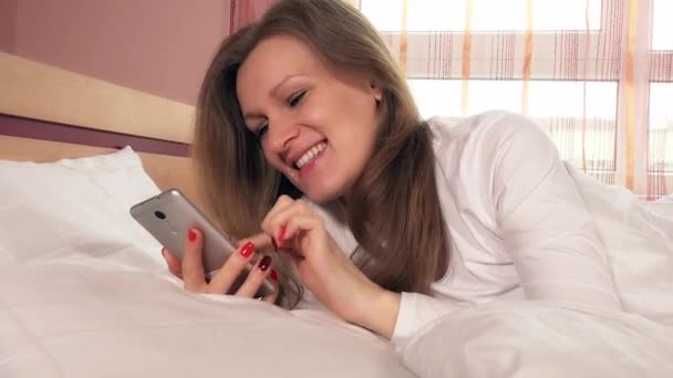 Jovem mulher sorridente conversando online com o smartphone — Vídeo de Stock