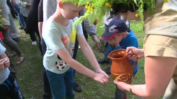 Children and adult people wash hands and faces in annual midsummer holiday — Stock Video