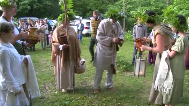 Senior priest wash hands and face with water from forest source. Midsummer day — Stock Video