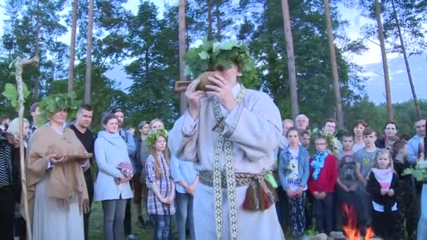 Старый священник пьет из деревянной чаши и молится богам — стоковое видео
