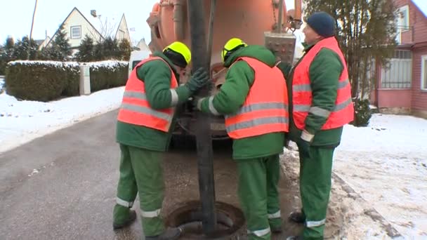 Tres operador que usa manguera larga para limpiar bien el pozo de aguas residuales de las heces — Vídeos de Stock