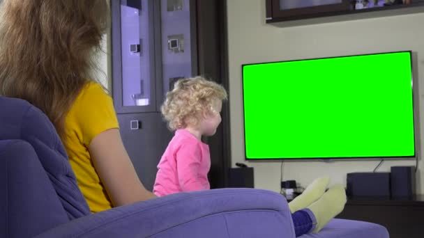 Mor och hennes stygg dotter flicka titta Tv. Green chroma key skärmen — Stockvideo