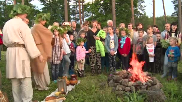 司祭の男と人々は、暖炉の炎に穀物を投げる — ストック動画