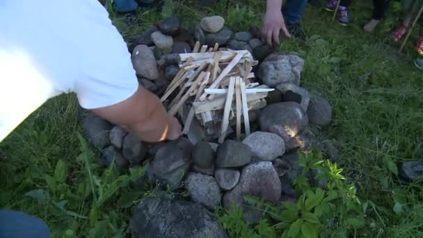 Mensen zetten stenen op open haard. Symbolische tradities in heidense midzomer vakantie — Stockvideo