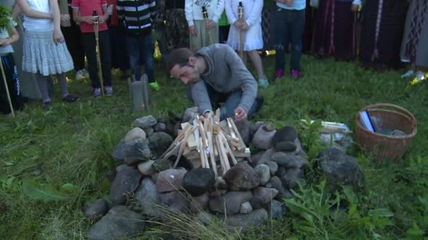 Man sätter eld och människor runt öppen spis i holiday midsommarfirande — Stockvideo