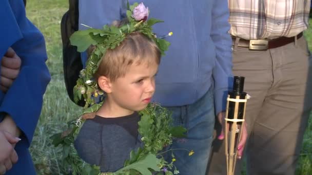 Child boy with flower and plants crown at midsummer holiday event — Stock Video