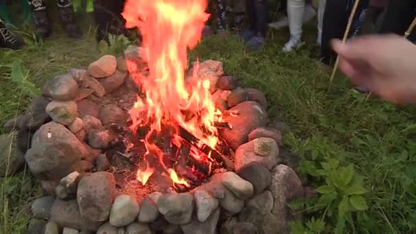 La gente arroja grano a la llama de la chimenea — Vídeos de Stock