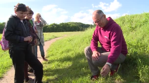 Šťastný muž botanik informuje turisty o rostlinách — Stock video