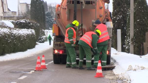 Arbetstagare med särskild utrustning upplåta avloppsvatten dräneringssystem på gatan — Stockvideo