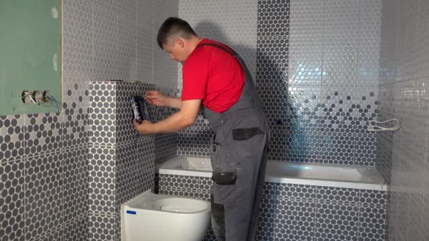 Worker man install mechanisme van toilet water blozen systeem — Stockvideo