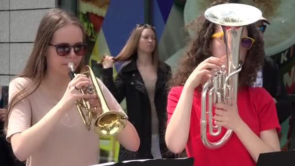 年轻的音乐家女孩在街头公共活动中演奏管乐器. — 图库视频影像