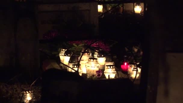 Alejar la llama de las velas encendidas en la lápida del cementerio oscuro. 4K — Vídeos de Stock