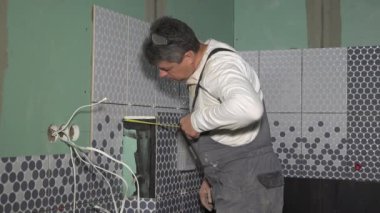 Metre aracı ile dolap çerçevesi duvar ölçme kiremit tabaka adam