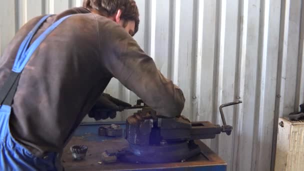 Чоловік працівник подрібнює іржавий метал з інструментом малини в гаражі . — стокове відео