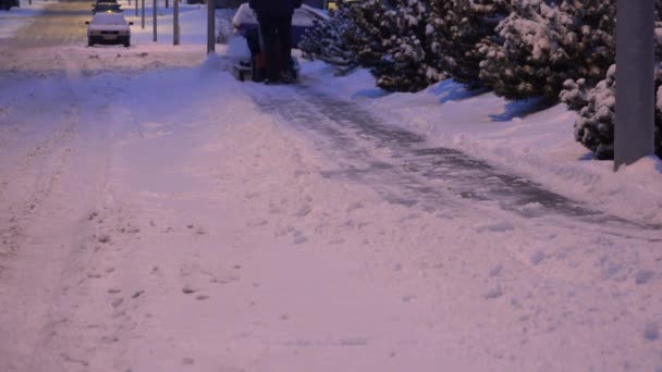 Arbeiter reinigen schneebedeckten Bürgersteig mit Schneeräummechanismus. 4k — Stockvideo