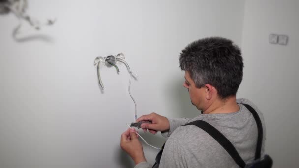 Worker prepare wires to connect socket rosette frames in gypsum wall holes — 비디오